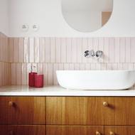 V koupelně zaujmou jemné obklady v růžové barvě i elegantní umyvadlo na skříňce s odkládací plochou s motivem mramoru.