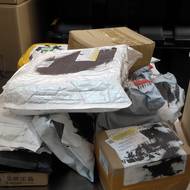 Krabice se rychle hromadí. Někteří návštěvníci odcházejí s jedním balíčkem, jiní si jich berou několik.