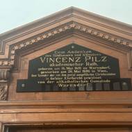 Deska vytvořená jako připomínka památky významného sochaře Vinzenze Pilze, který varnsdorfskému kostelu daroval jeho skvost, mramorovou sochu Krista.
