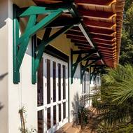 Tmavě zelené prvky působí na pozadí bílé fasády domu velmi dekorativně.