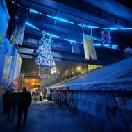 Velká prádelní šňůra s oblečením připomíná realitu lidí bez domova, kteří pod mostem Milénia žijí. Světelnou instalaci vytvořili studenti z Nerudovky, plzeňské střední odborné školy obchodu, užitého umění a designu.