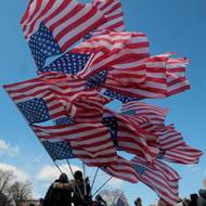 Jeden ze symbolů protestů proti Donaldu Trumpovi - americká vlajka nesená hlavou dolů