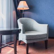 Kužel světla linoucí se ze stojací lampy jasně vymezuje zónu pro čtenářský koutek.