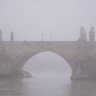 Karlův most a jinak šedo. Pražské panorama zalila mlha. 