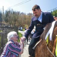 Obyvatelé líbají kříž, který nese první z jezdců.
