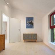 Interiér je zařízený kusy nábytku z původní chaty i novými prvky.