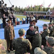 Kim Čong-un objímá velitele za nadšeného (a zřejmě povinného) potlesku publika. 