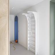 Žebřiny v chodbě v bílém decentním odstínu se staly oblíbeným solitérem aktivních členů rodiny.