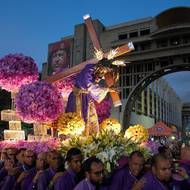 Barevné procesí ve venezuelském Caracasu. Za sochou Krista i 13 let po smrti visí další místní symbol - Hucho Chávez.