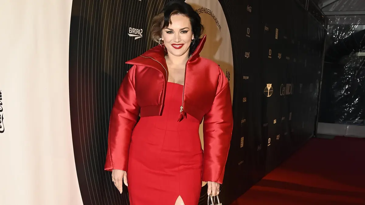 Co se skrývá za rudými šaty Ewy Farne na Cenách Anděl? Víme, který designér je navrhl a proč mají trnitý rozparek