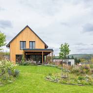 Z domku přes terasu vede cesta na zahradu.