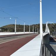 Postranní chodníky kryje probarvený červený asfalt. 