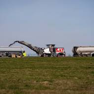 Na hlavní dráze teď místo letadel popojíždí nákladní vozy a frézy. 