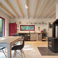 Komín slouží jako přirozený dělicí prvek v hlavním obytném prostoru chaty.