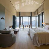 Ložnice má chytré uspořádání - lůžko je ukryto v její hloubce, díky čemuž se tu lze kochat výhledem, ale první paprsky hned spící nebudí.