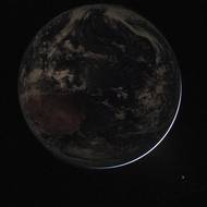 Snímek Země v noci z lodi Orion mise Artemis II. V pravém dolním rohu osvětluje sluneční světlo okraj planety