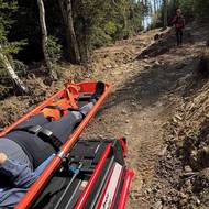 Zraněný turista ležel v nosítkách.