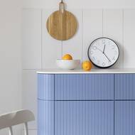 Oblá rastrovaná modrá komoda je dominantním prvkem jídelního koutu.