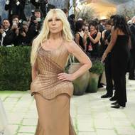 V šatech pískové barvy s propracovaným korzetovým vrškem to slušelo i módní návrhářce Donatelle Versace. 