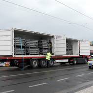 Materiál v kontejnerech na nábřeží navážela řada vozů.