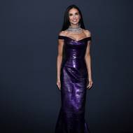 Temně fialové šaty Gucci z krokodýlí kůže ladily s havraní hřívou herečky. Na krku se vyjímal bohatě zdobený náhrdelník od francouzské firmy Boucheron.
