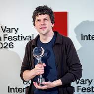 Jesse Eisenberg se fotí s cenou.