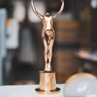 Hlavní cena Mezinárodního filmového festivalu Karlovy Vary v podobě dívky zvedající křišťálovou kouli v sobě spojuje zdánlivě protichůdné vlastnosti – je pevná, těžká, ale zároveň povznášející.